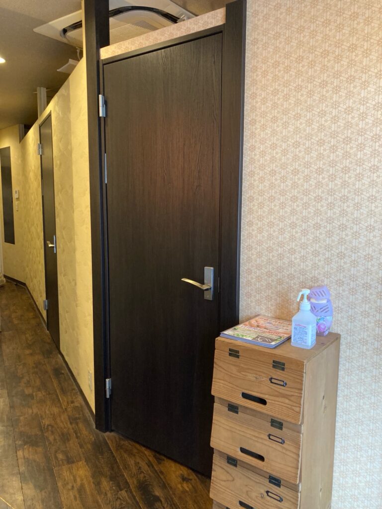 三華堂の施術室入口と廊下の様子。木の温もりを感じる落ち着いた雰囲気で、来院者をやさしく迎える空間。