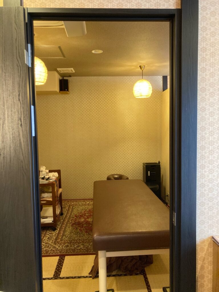 三華堂の施術室の入口から見た室内の様子。畳と木のぬくもりに包まれた落ち着いた空間で、静かに施術を受けられる。